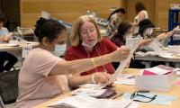 Two women sitting at a table review a ballot