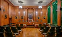 Empty courtroom with chairs and a judge's bench at the front.