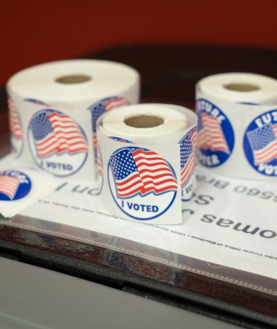 Rolls of stickers that say "I Voted" and have American flags on them